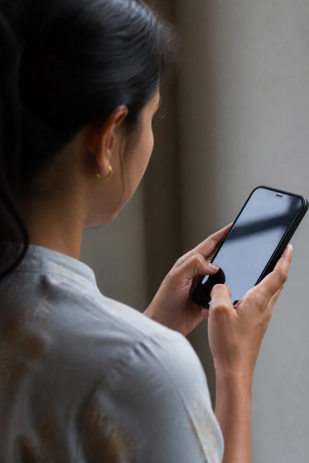 manos de una persona sosteniendo un smartphone, la pantalla iluminada muestra la interfaz de una conversación de whatsapp con mensajes de texto y burbujas de chat.
