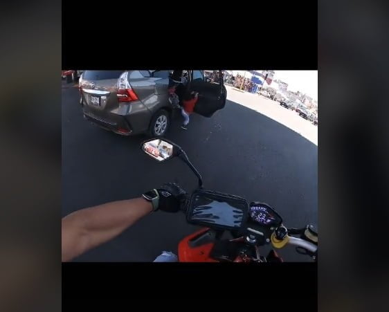 niño abrió la puerta de un carro en movimiento y quedó colgando