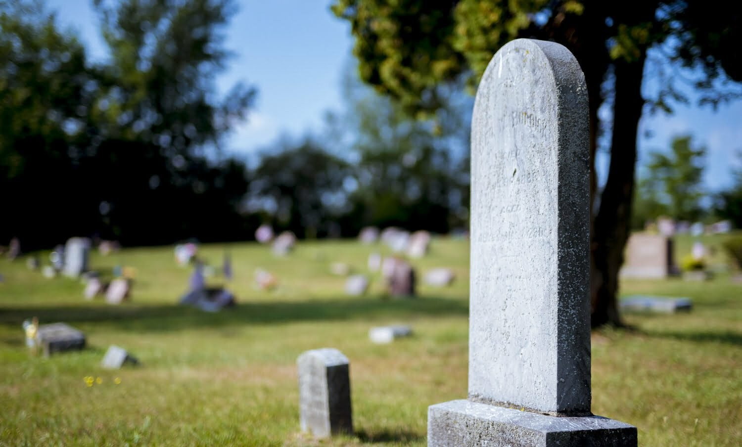 primer plano de una lápida en un cementerio, para hablar del miedo a la muerte