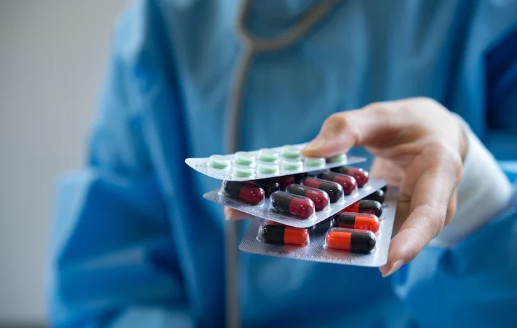 doctor entrega tres blisters de medicamentos - nimesulida