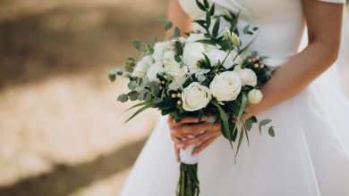 Mujer con vestido de boda y con floren en mano | boda expareja