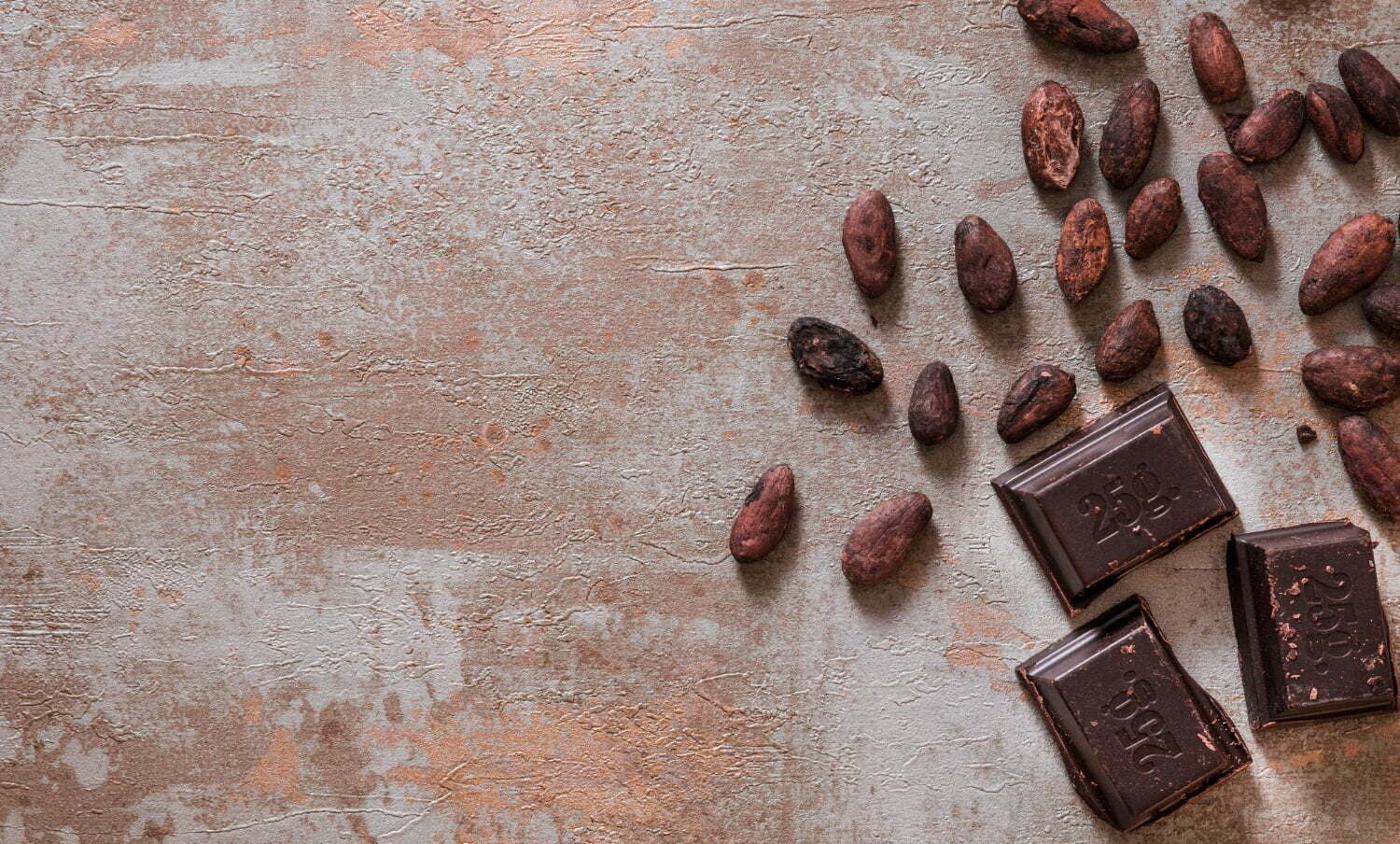 Piezas de chocolate con granos de cacao en bruto en el fondo rústico - cacao y la hipertensión