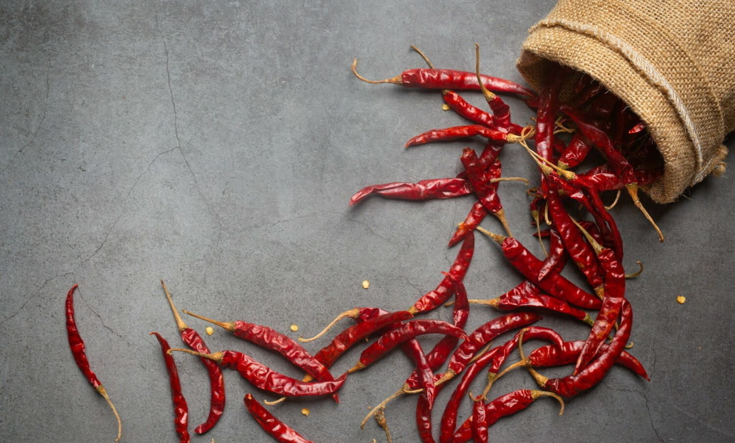 varios chiles secos saliendo de un saco pequeño