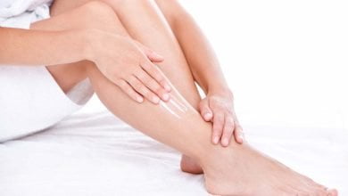 mujer aplicando crema hidratante casera en sus piernas
