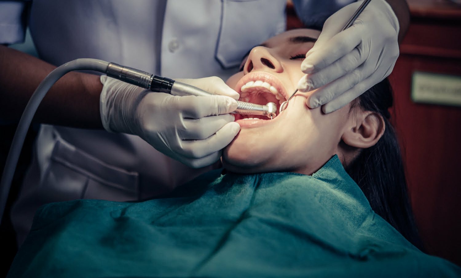 dentista tratando a mujer con caries