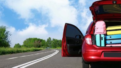 Coche familiar con maletero abierto lleno de equipaje en la carretera. / viajes por carretera / kit básico para viajar por carretera / fin de año