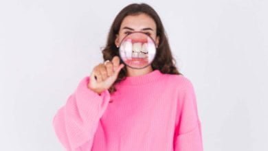 mujer con lupa en los dientes, para ver si tiene placa y sarro