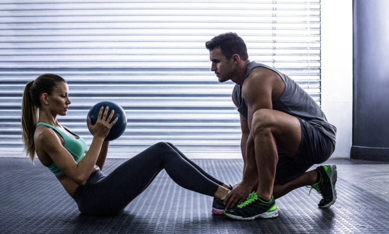 pareja muscular haciendo ejercicio de bola abdominal / abdominales