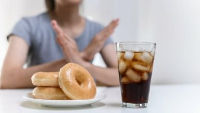 Mujer joven rechazando comida chatarra / desayuno / defensas