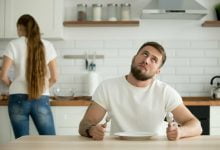 El marido aburrido esperando la cena o el desayuno cocinado por la esposa / hambre emociones