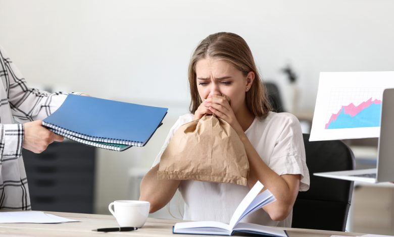 Mujer con ataque de pánico en el lugar de trabajo / hiperventilación