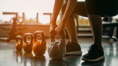 Mujer en equipo de ejercicio parada / pesas rusas / entrenamiento con pesas