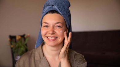 mujer hidratando su piel seca de la cara base de maquillaje / cuidar la piel