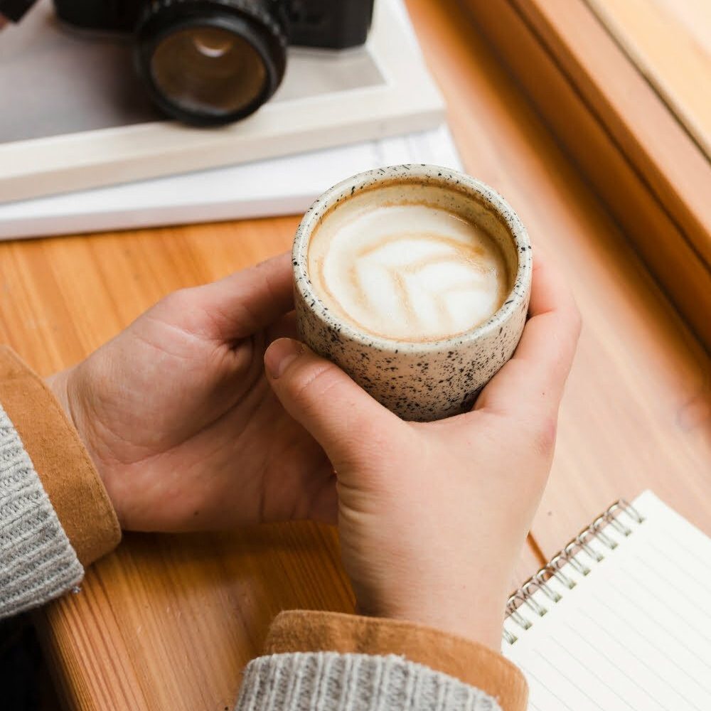 manos sosteniendo taza de café