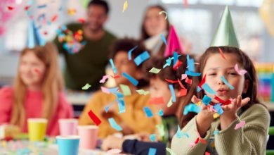 niña en fiesta para niños soplando confeti / septiembre