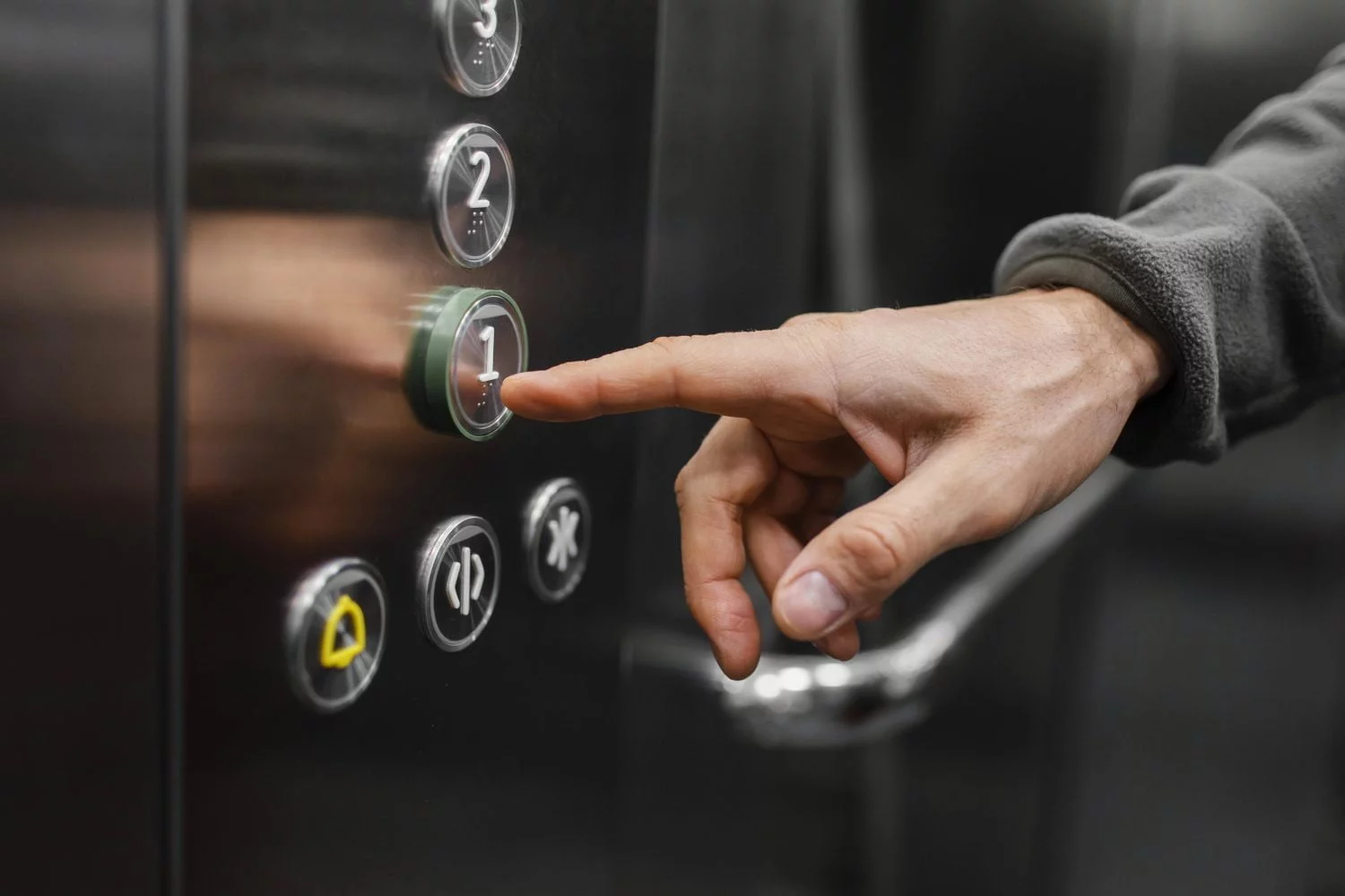 mano tocando los botones de un ascensor - Medellín