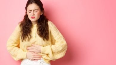 mujer joven con dolor en su estómago por aparición de gastritis período menstrual osteopatía