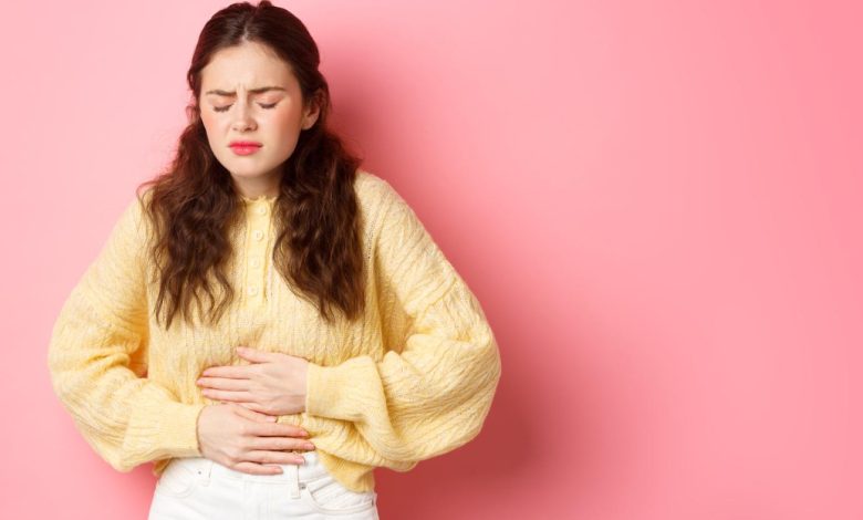 mujer joven con dolor en su estómago por aparición de gastritis período menstrual osteopatía