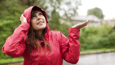 mujer bajo agua de lluvia