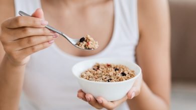 Imagen recortada de una mujer sosteniendo un tazón con granola o harina de avena casera / desayuno