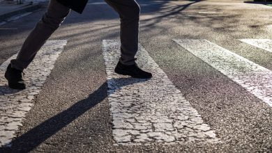 hombre tratando de no pisar las líneas negras de un paso peatonal / manías