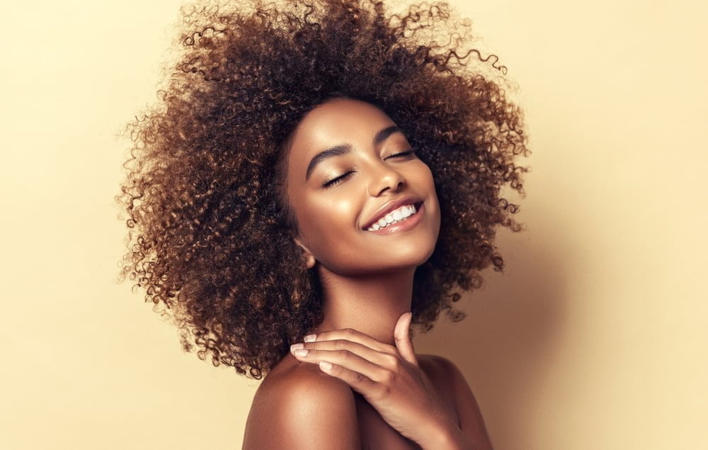 Retrato de belleza de una mujer sonriente con peinado afro / piel morena