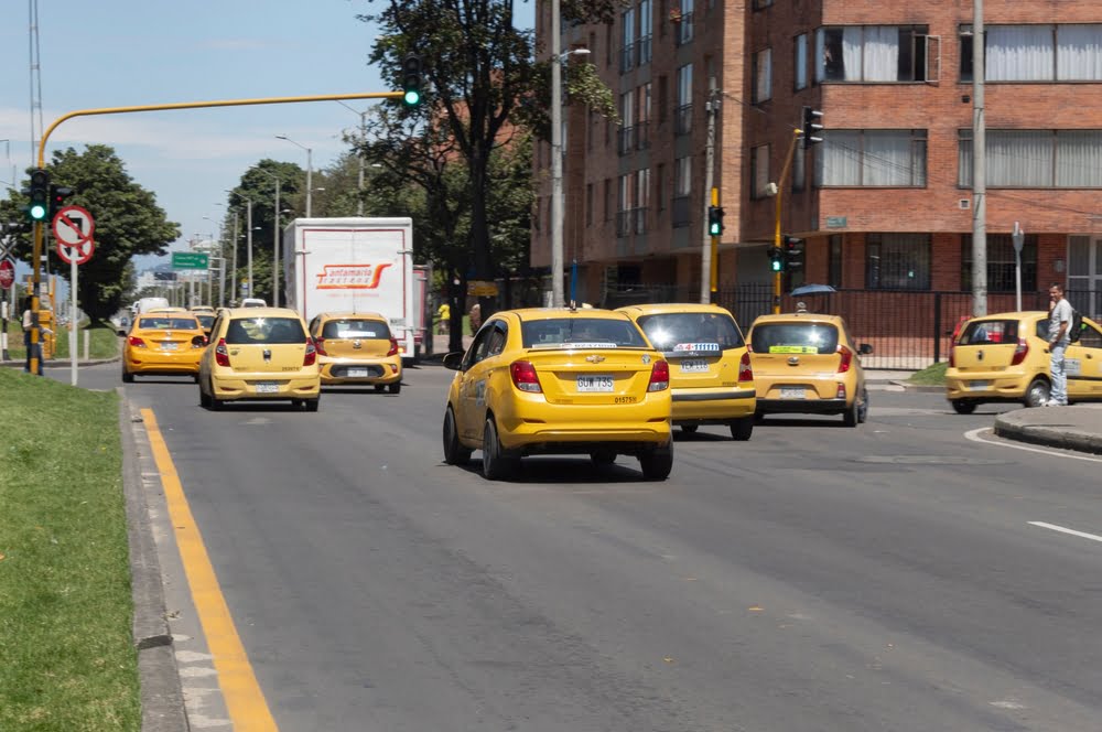 Una gran cantidad de taxis que transitan por la 9ª avenida durante un evento de Bogotá sin coche / taxistas / compensación de combustible / paro nacional de taxistas