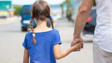 Un hombre vestido de blanco lleva a una niña de la mano por la calle / secuestrando niños / qué hacer si se pierde